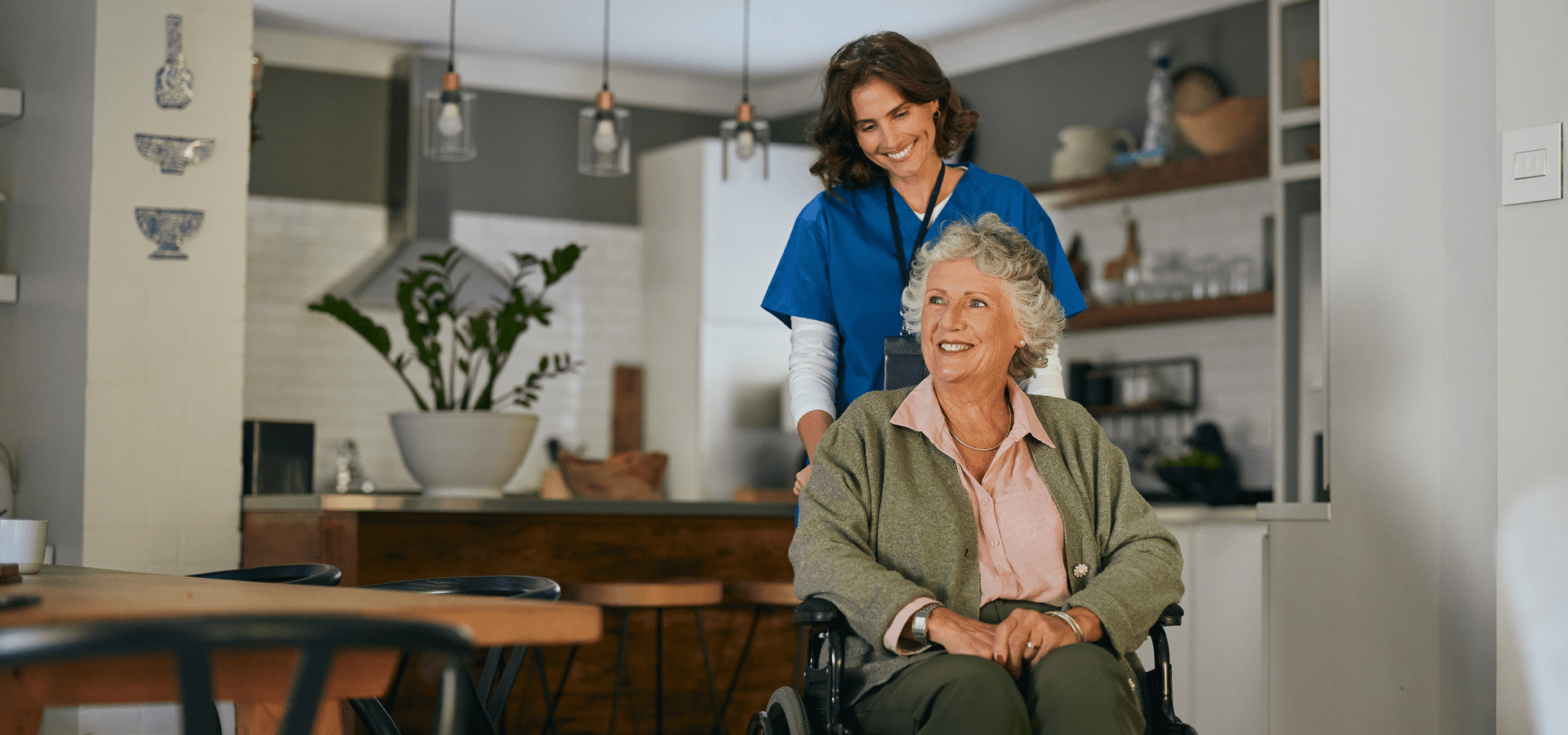 Caregiver assisting elderly woman in wheelchair.